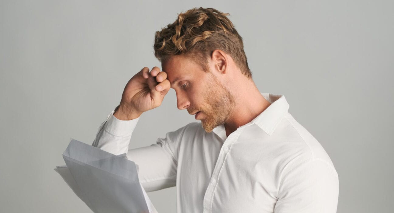 Man reviewing his finances and dealing with financial stress