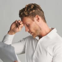Man reviewing his finances and dealing with financial stress