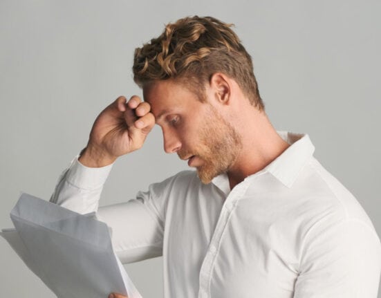Man reviewing his finances and dealing with financial stress