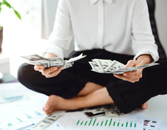Person holding cash and counting money for financial success.