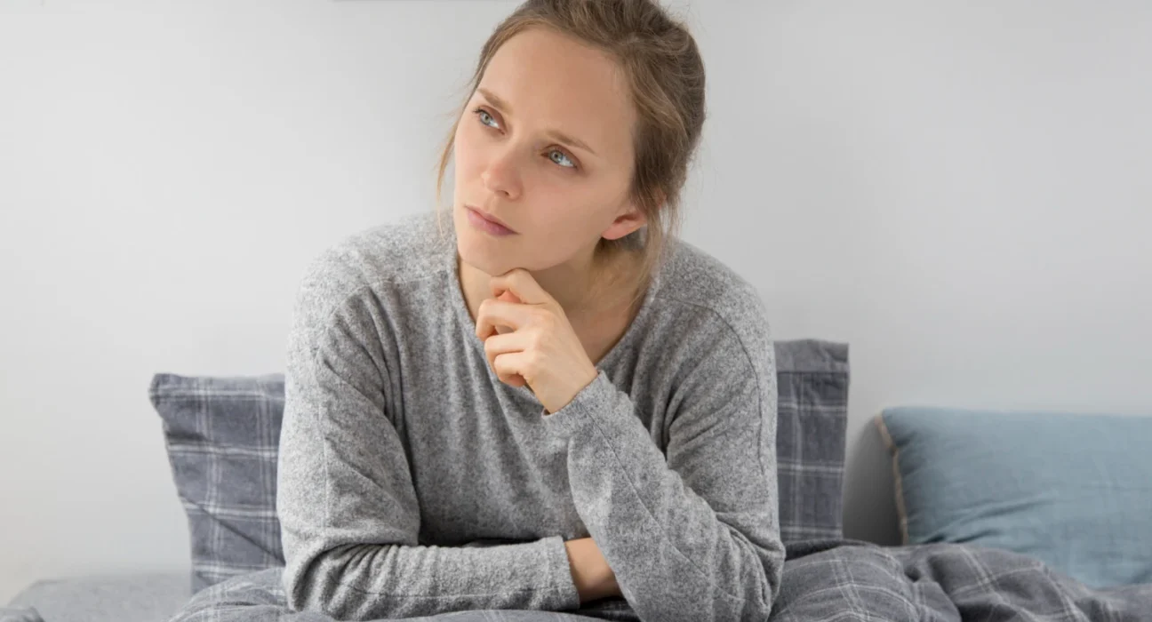 Woman thinking deeply, contemplating overthinking effects on decision making.